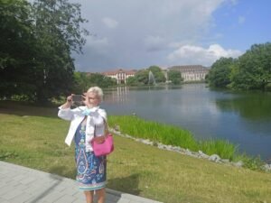 Frau Christiane steht am Ufer des Kleinen Kiel mit Wasser und Bäumen